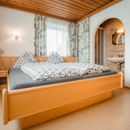 Helles Doppelzimmer mit Sitzbereich und Rundbogen