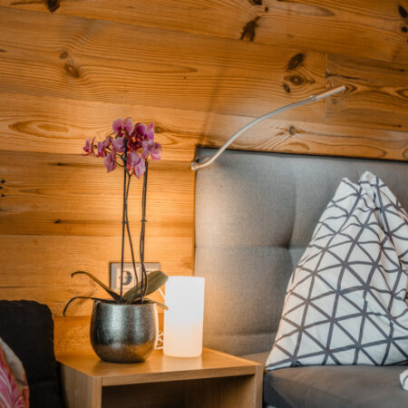 Nachttisch mit Orchidee neben dem Doppelbett