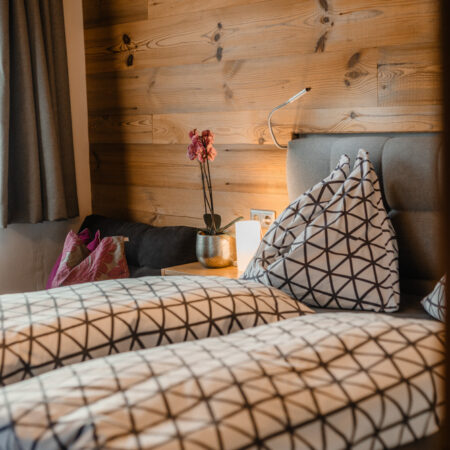 Doppelbett mit gemusterten Kissen in der Ferienwohnung