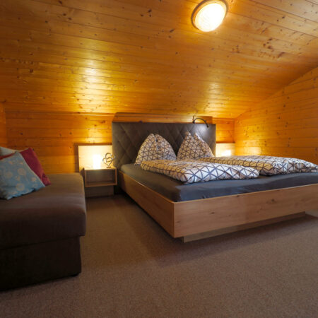 Wohn- und Schlafraum mit Doppelbett und Sofa