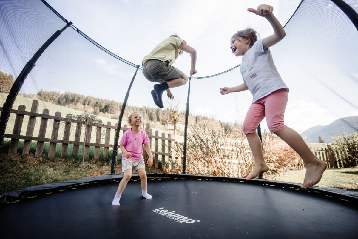 Kinder springen gemeinsam auf dem Trampolin
