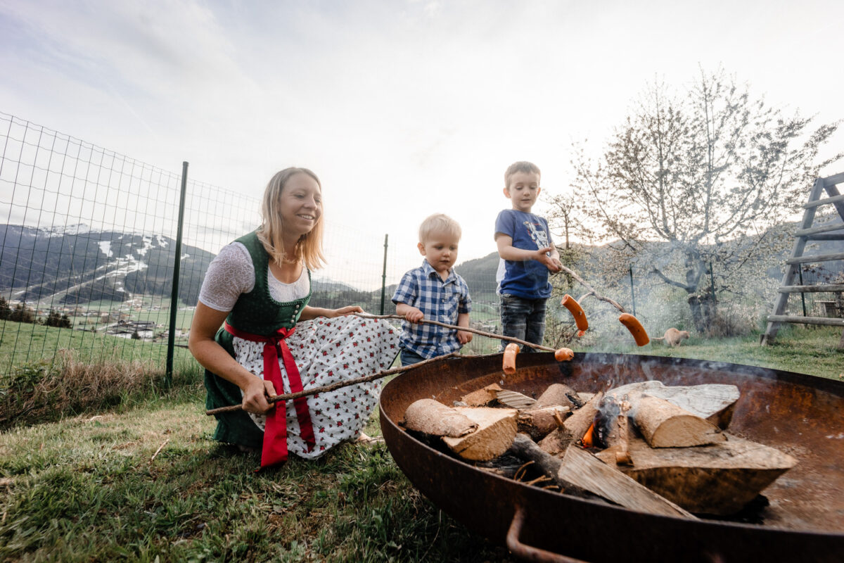 Kinder stehen mit der Gastgeberin an der Feuerschale