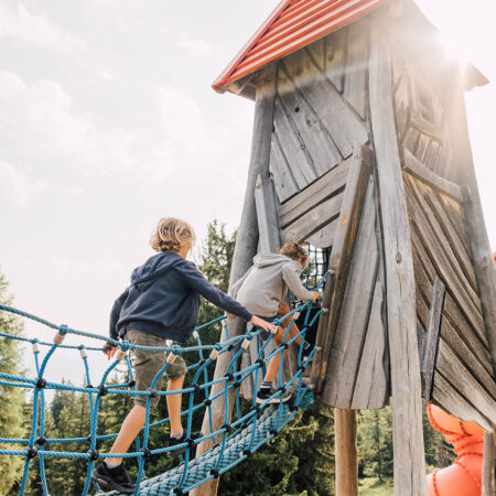 Mädchen rutscht auf einem Abenteuerspielplatz